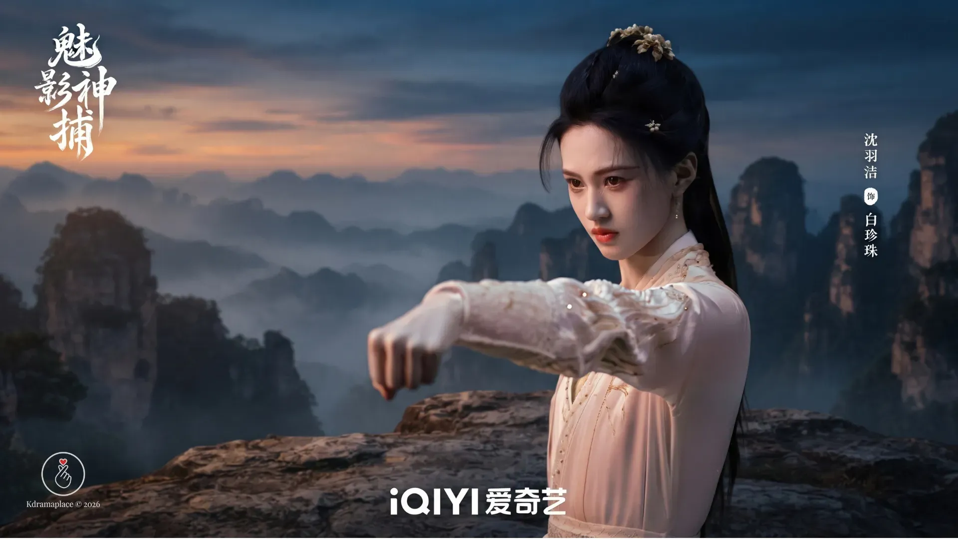 A atriz Shen Yujie em posicao de combate em cenario de montanhas